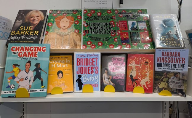 A display of books by women's authors at the library, there are also decorative posters.